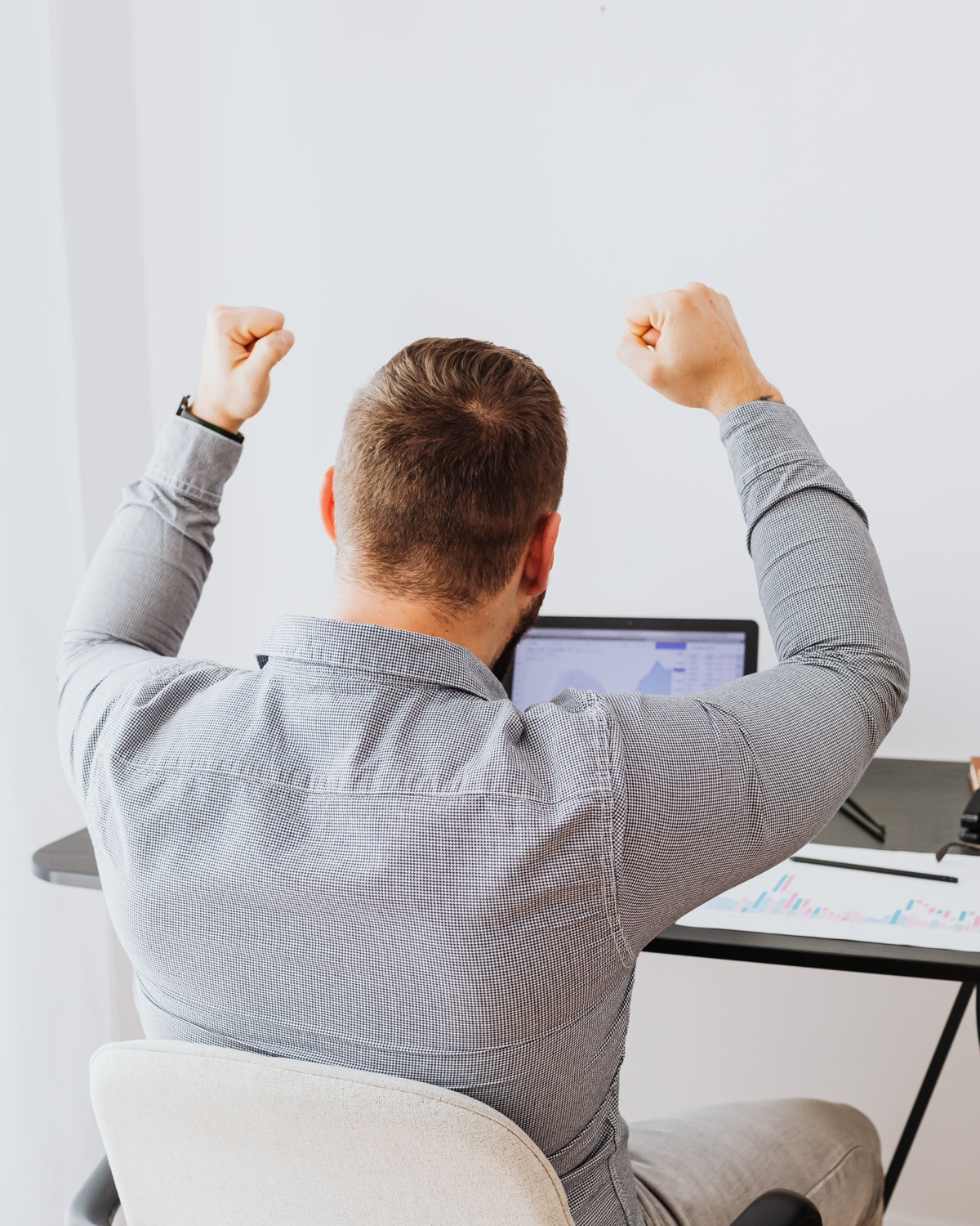 Happy homeowner celebrating at his desk with his paperwork